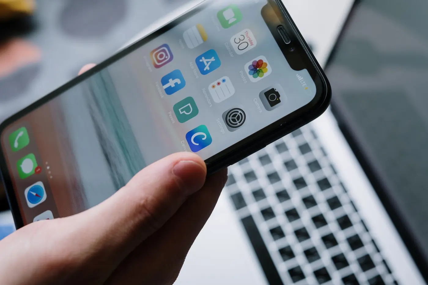 Hand holding a smartphone displaying a modern mobile app interface
