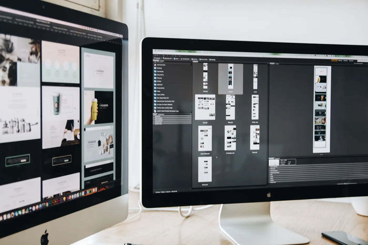 Designer workstation with large monitors displaying website layouts